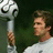 A pixelated image shows a person holding a large trophy with a soccer ball on top, next to text reading "Impossible Is Nothing".