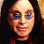 A 50x50 pixel buddy icon split into two sections: a left-side portrait of a person with long dark hair and blue-tinted glasses, and a right-side green background with bright green text reading "Original Icons .com" in a stylized font.