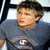 Two side-by-side pixelated images of a person in different outfits and poses, one with short dark hair wearing a gray shirt with a white logo, the other with longer brown hair in a white tank top.