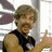 Pixelated image of a person with light brown hair and a mustache giving a thumbs-up gesture, surrounded by pink text on a black background.