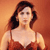 Static pixelated image of a woman with shoulder-length dark brown hair wearing a sleeveless red dress against an orange background.