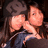 Pixelated image of two figures in a close embrace, one with long dark hair and the other with short light brown hair against a dark background.