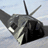 Static pixelated image of a military aircraft in flight against a light blue sky background with visible anti-aliasing and dithering effects.