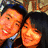 Two people smiling closely together in a pixelated photo with warm tones and dark hair.