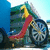 Animated icon shows a cartoon character with yellow hair and red dress riding a bicycle, text appears sequentially over the scene.