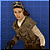 Pixelated figure in brown vest and white shirt against blue background, head turned left with slight smile, one arm extended forward.