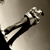 Pixelated grayscale image of a stylized figure with outstretched arms against a gradient background.
