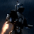 Pixelated static image of a dark figure holding a glowing object against a dark background with visible dithering and low-resolution artifacts.