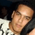 A person in a white shirt with black patterns rests their head on a dark surface, viewed from multiple angles in a