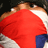A pixelated static image shows a person in red clothing with brown hair, partially obscured by another figure in white and blue.
