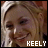 A pixelated close-up of a smiling person with light brown hair, wearing white text reading 'KEELY' at the bottom.