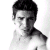 Black-and-white pixelated image of a person with short dark hair, shirtless torso visible, positioned against white background on left side.