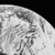 Pixelated grayscale image of a curved celestial body with cratered surface against black background
