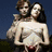 Two people embrace in a close-up pose with one person holding the other, set against a blue background.