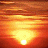 Animated sunset scene with horizontal light streaks over a bright sun on the horizon against warm orange and red sky.