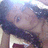 Pixelated image of a person with dark hair and light skin, wearing a white top against a blurred background.