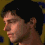Four pixelated views of a person with short dark hair against a yellow background with blue accents, showing different head angles and expressions.
