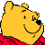 Pixelated yellow cartoon bear head with red garment, smiling expression on gray background.