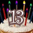 Pixelated birthday cake with large brown '13' numerals on top, surrounded by multicolored candles against a dark background.