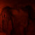 Dark red and black pixelated image with indistinct shapes and no visible text or recognizable subjects.