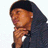Pixelated image of a person with dark hair wearing a dark jacket, hand near chin in contemplative pose against white background.