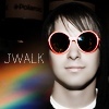A static icon shows a person wearing large round sunglasses with pinkish-red frames, a white collar, and a dark top, with 'JWALK' text and a rainbow gradient in the background.
