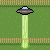 Pixel art of a flying saucer emitting a green beam onto grassy ground with wooden fences.