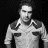 Static grayscale pixel art of a person in a collared shirt with shoulder details, set against a black background.