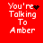 Red background displays white pixelated text 'You're Talking To Amber' with animated black symbols replacing the apostrophe in 'You're'.