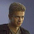 Pixelated static image of a person with short brown hair wearing dark clothing against a gradient background.