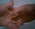 A hand with fingers curled into a loose fist against a light blue background, showing subtle motion changes