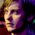 Pixelated close-up of a person's face with light skin tone, dark hair, and purple-toned background elements.