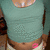 A person in a teal crop top and light shorts with a pink circular mark on their lower abdomen, shown across three
