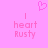 Pixelated pink heart symbol above two identical text blocks reading 'I heart Rusty' on a solid pink background.