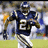 A pixelated image of a football player in a dark blue jersey with number 27, running on a field, surrounded by a solid blue background with white text.
