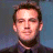 A pixelated image of a person with short brown hair against a blue background, next to green text reading 'Original Icons .com' on a dark green backdrop.