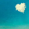 A heart-shaped cloud floats against a gradient blue sky transitioning from deep cyan to light turquoise, with a faint horizon line at the bottom.