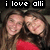 Two people with long brown hair wearing red tops pose closely together under text reading 'i love alli' in a pixelated style.