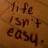 Brown pixelated background with dark brown text reading 'Life isn't easy.' in a casual handwritten style.