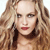 Pixelated close-up of a person with long wavy light brown hair, red lips, and dark eyes against a white background.