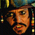 Pixelated close-up of a person's face with brown hair, dark eyes, and a mustache, set against a dark background with scattered colored pixels.