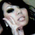 Pixelated close-up of a pale-skinned anime-style character with large dark eyes and a small mouth, set against a dark background.
