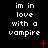 Black background with white pixelated text reading 'im in love with a vampire' arranged in three , red plus and X symbols scattered across the image