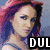 Pixelated image of a person with red hair and blue eyes, wearing a blue top against a light background.