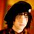 Static pixelated image of a person with dark hair and light skin against warm orange background, likely from Santa Clause 2 movie icon set.