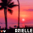 Pixelated sunset scene with palm trees, a bright sun over water, and text reading 'ARIELLE' flanked by two pink heart symbols.