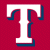 Static pixelated icon featuring a large white letter T with blue outline on solid red background, rendered in low-resolution style typical of early internet graphics.