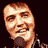 Pixelated static image of a person's face with brown hair and light skin tone against dark background, rendered in low-resolution 256x256 pixels.