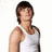 Pixelated static image of a person with short brown hair wearing a white sleeveless shirt against a white background.