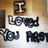 A pixelated image with text "I Loved You First" on a light background, showing slight variations in brightness and contrast across four views.